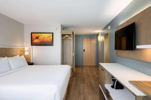 a hotel room with a bed and a flat screen tv at Wyndham Garden Winnipeg Airport in Winnipeg