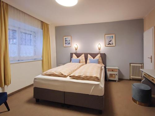 a bedroom with a large bed and a window at Koller, Pension Haus in Kitzbühel