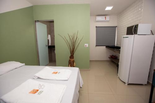 a kitchen with a white table and a refrigerator at Jahu Center Plaza Flats in Jaú