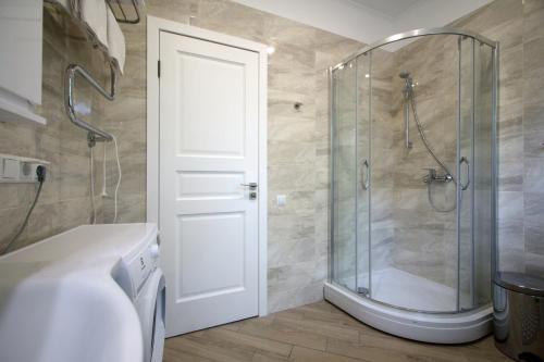 bagno con doccia e porta in vetro di Alve Apart Hotel a Jūrmala