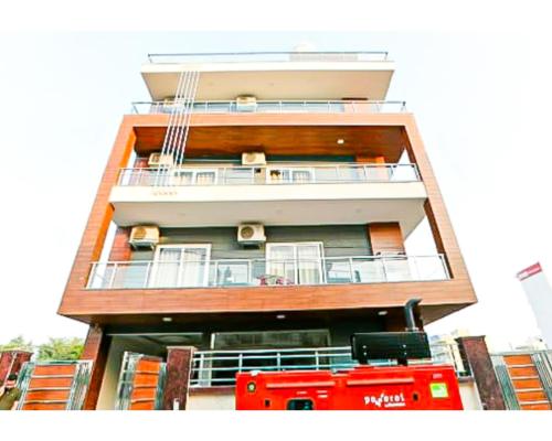 a tall building with a red bus in front of it at Hotel Shree Shyam By WB Inn in Gurgaon