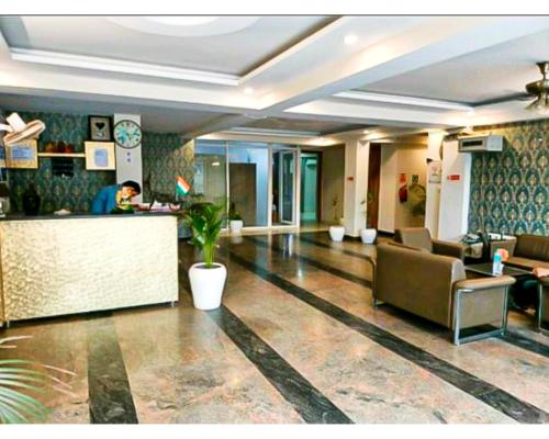 a lobby with a counter and a person in a room at Hotel Shree Shyam By WB Inn in Gurgaon