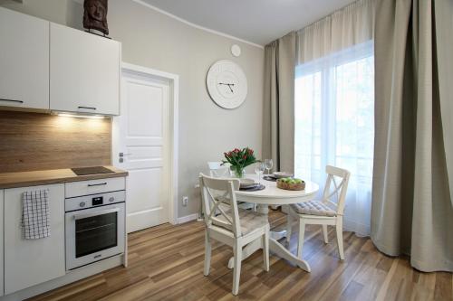 a kitchen with a table and chairs in a kitchen at Alve Apart Hotel in Jūrmala