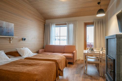 a hotel room with two beds and a couch at Ski-Inn AurinkoRinne in Ruka
