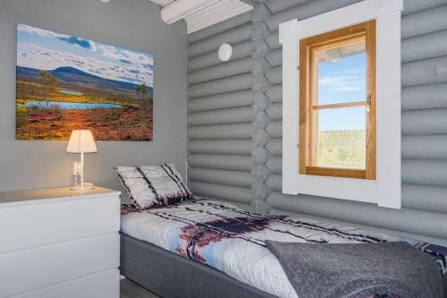 Schlafzimmer mit einem Bett und einem Fenster in der Unterkunft Kieppi, open your door and enjoy the wilderness in Utsjoki