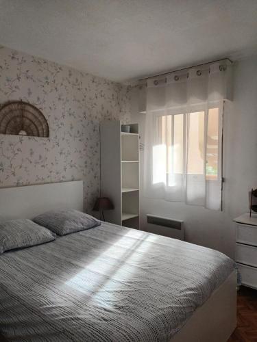 une chambre avec un grand lit et une fenêtre dans l'établissement Mauresque, à Arcachon