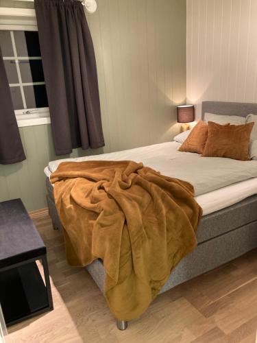 Un dormitorio con una cama con una manta. en Beautiful view - close to the sea, mountains and nature en Kvaløya