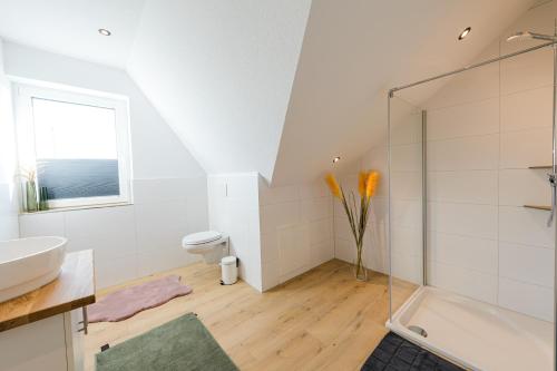 een badkamer met een douche, een wastafel en een toilet bij Ferienpark Harkebrügge Haus Spiekeroog in Barßel