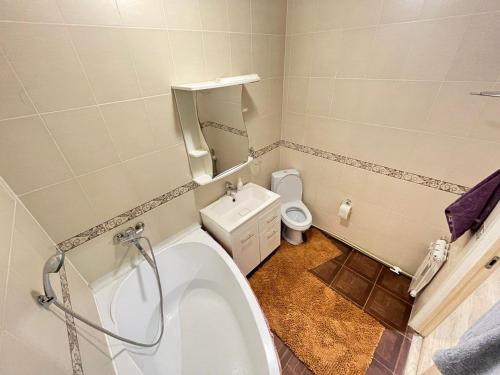 uma casa de banho com banheira e WC em Дом просто Сказка em Atyrau