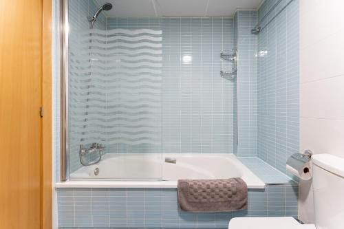 bagno piastrellato blu con vasca e servizi igienici di Spacious 2bed family apartment in Puerto Marina a Benalmádena