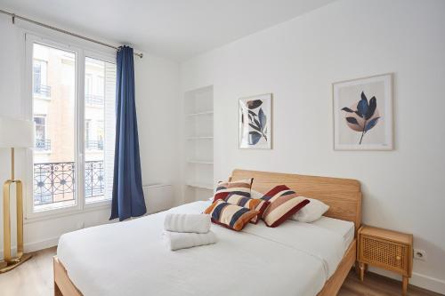 1 dormitorio con 1 cama con sábanas blancas y ventana en Residence Neuilly Bois de Boulogne by Studio prestige, en Neuilly-sur-Seine