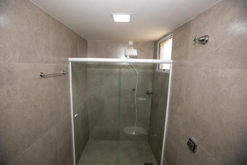 a shower with a glass door in a bathroom at Jahu Center Plaza Flats in Jaú