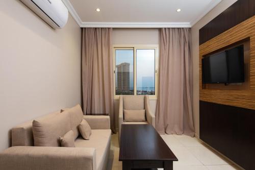 een woonkamer met een bank en een tv bij Mirada Purple - Obhur in Jeddah