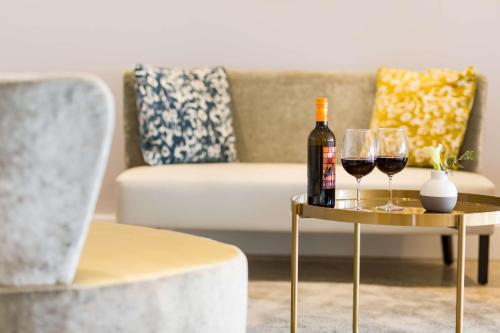 a living room with a table with wine glasses and a couch at NH Utrecht in Utrecht