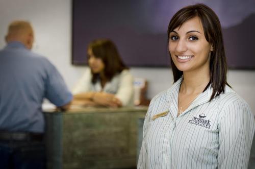 a woman is standing in front of a desk at Westmark Fairbanks Hotel and Conference Center in Fairbanks