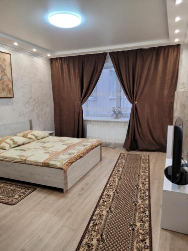 1 dormitorio con cama y ventana en Апартаменты по Панаса Мирного., en Khmelʼnytsʼkyy