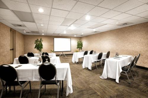 a conference room with white tables and chairs and a screen at Westmark Fairbanks Hotel and Conference Center in Fairbanks