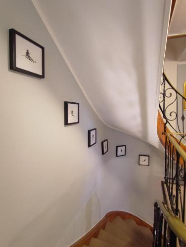 a staircase with framed pictures on the wall at Koller, Pension Haus in Kitzbühel