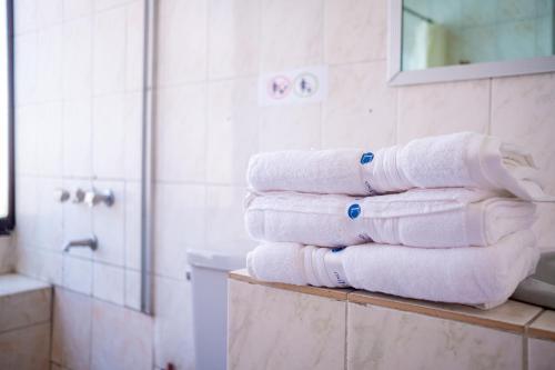 una pila de toallas en un estante del baño en Unión Plaza Hotel en Cochabamba