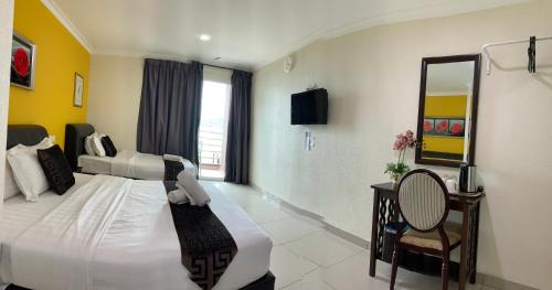 a hotel room with a bed and a mirror at Lumuda Hotel in Lumut