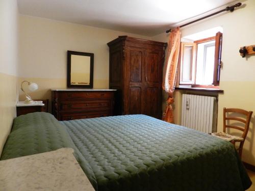 a bedroom with a bed and a dresser and a window at Casa Nonna Elisa in Scanno