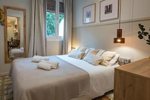 a bedroom with a large white bed with towels on it at Habitat Apartments Sweet Sagrada Familia in Barcelona