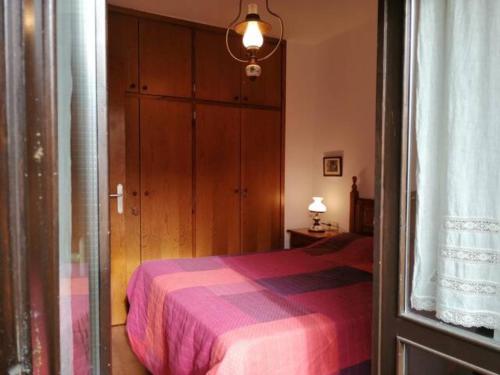 a bedroom with a bed with a purple blanket at Apartamento Herbasabina 3 con jardín comunitario y piscina en verano in Pla de l'Ermita