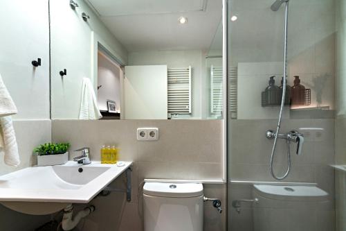 a bathroom with a shower and a toilet and a sink at Habitat Apartments Sweet Sagrada Familia in Barcelona