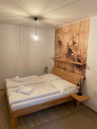 - une chambre avec un lit et une tête de lit en bois dans l'établissement Apartmán Hubertus – Karlova Studánka, à Karlova Studánka
