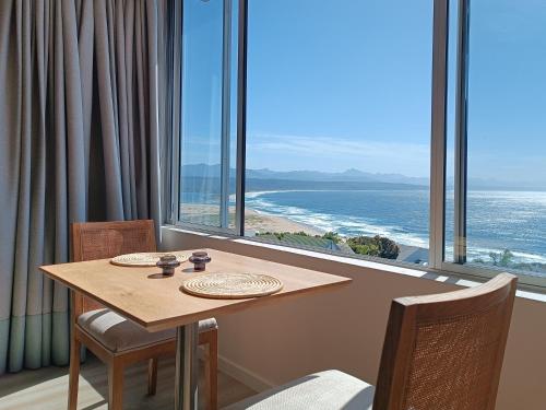 a table and chairs with a view of the ocean at Summer Sea in Plettenberg Bay