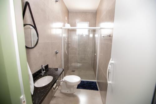 a bathroom with a shower and a toilet and a sink at Jahu Center Plaza Flats in Jaú