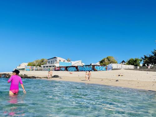 a woman standing in the water at a beach at Villa Maimouna les pieds dans l'eau in Saint-Pierre