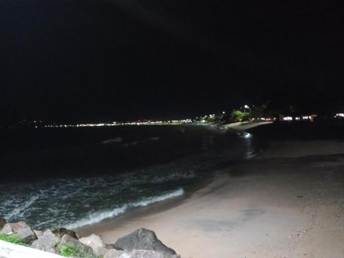 a view of a beach at night with the ocean at Apts centro Ubatuba in Ubatuba