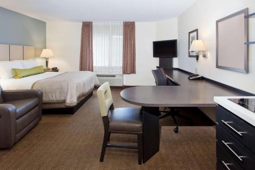 a hotel room with a bed and a desk with a table at Sonesta Simply Suites Somerset in Somerset