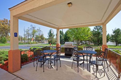 a patio with tables and chairs and a grill at Sonesta Simply Suites Somerset in Somerset