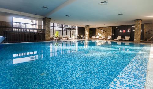 a large pool with blue water in a hotel at Hotel Bansko SPA & Holidays - Free Parking in Bansko