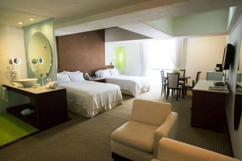 a hotel room with two beds and a mirror at Bel Air Business Salamanca, Trademark by Wyndham in Salamanca