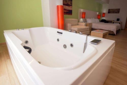 a large white bath tub in a living room at Bel Air Business Salamanca, Trademark by Wyndham in Salamanca