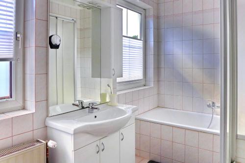 a bathroom with a sink and a tub and a mirror at Ferienwohnung Ybbsperle in Waidhofen an der Ybbs