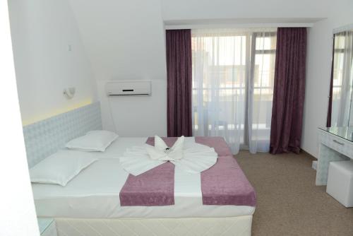 a bedroom with a bed with a bow on it at Diamond Kiten in Kiten