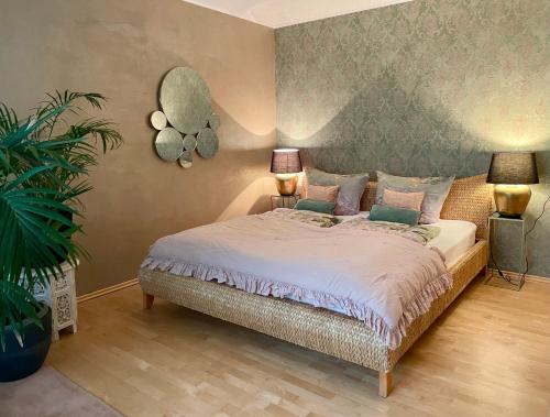 a bedroom with a bed with two lamps and a plant at Ferienwohnung Louise 50 m zum See in Kressbronn am Bodensee