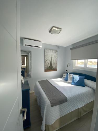 een slaapkamer met een bed met blauwe kussens bij Apartamento Oasis Palmeras 4 in San Bartolomé