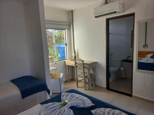 1 dormitorio con cama y baño con espejo. en Pousada Brisa e Mar, en Praia do Frances