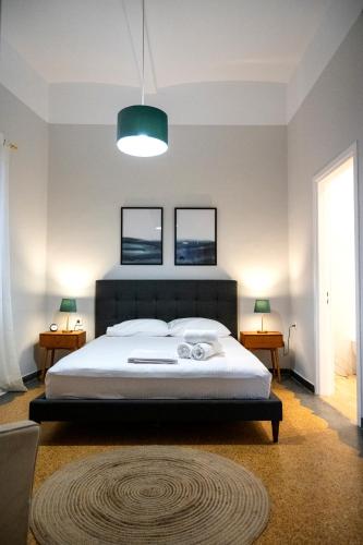 a bedroom with a large bed with two pictures on the wall at HomeResidence 2 in Ermoupoli