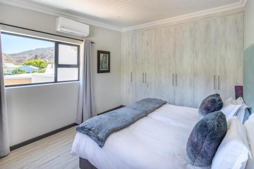 a bedroom with a bed and a large window at Mimosa Lodge in Montagu