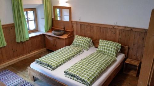 Schlafzimmer mit einem Bett mit grünen und weißen Kissen in der Unterkunft Ferienhof Leo in Steeg