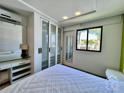 a bedroom with a white bed and a window at Marulhos Muro Alto, Apartamento Encantador in Porto De Galinhas