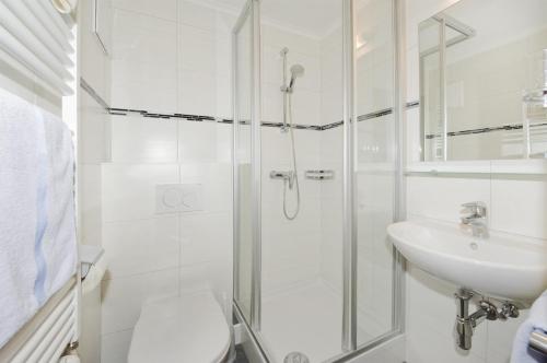 a bathroom with a shower and a toilet and a sink at Pension Riedlsperger in Saalbach Hinterglemm