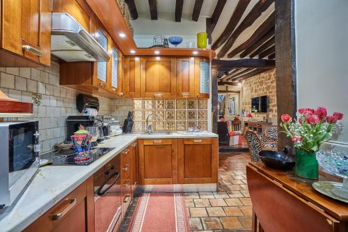 une grande cuisine avec des placards en bois et des fleurs sur le comptoir dans l'établissement Apartment in heart of Marais by Studio prestige, à Paris