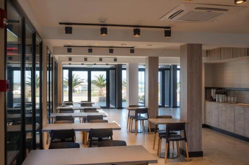 a row of tables and chairs in a restaurant at Arena Suites in Mar del Plata